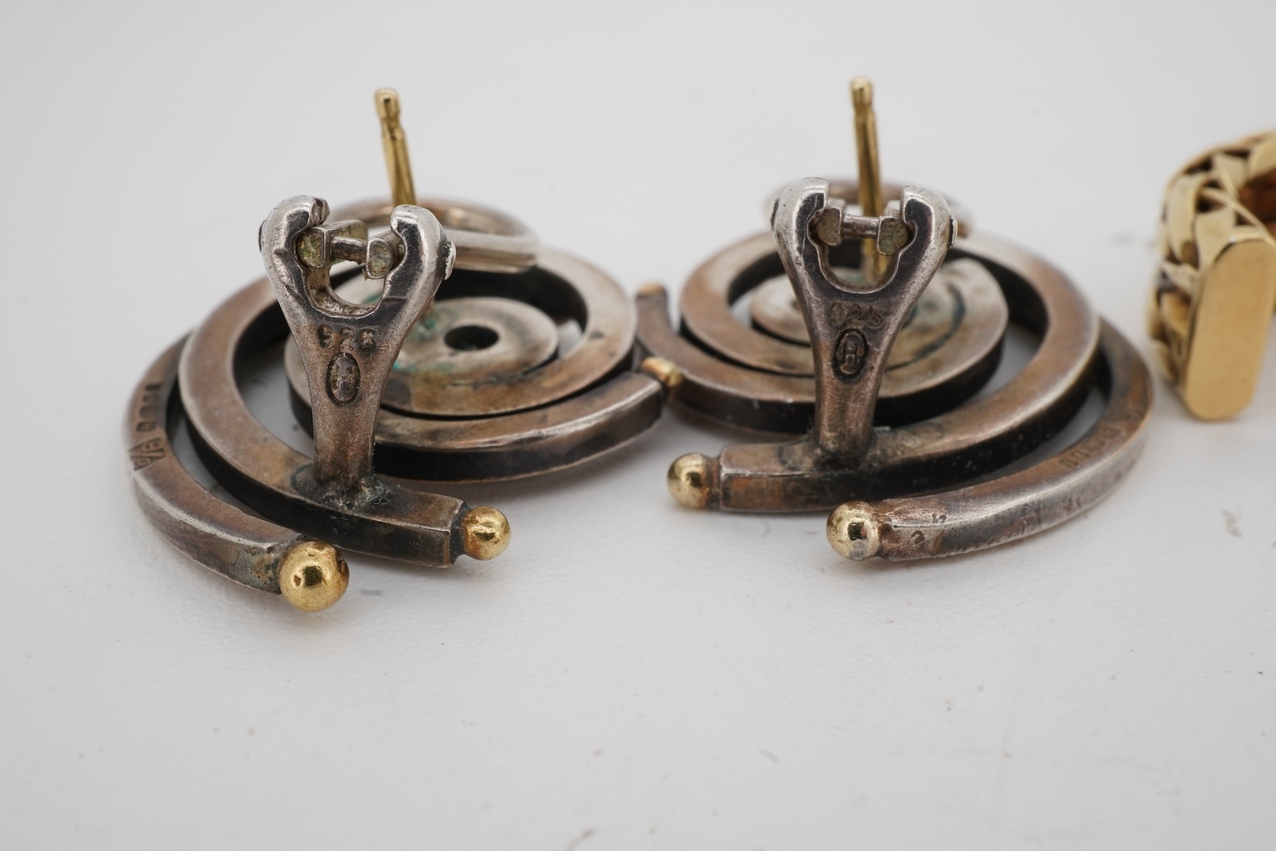 Two pairs of diamond earrings, comprising: one pair of woven design, set with brilliant-cut diamonds totalling approximately 0.10 carats, mounted in bicoloured 18ct gold, length 2.4cm each, post fittings, British hallmar